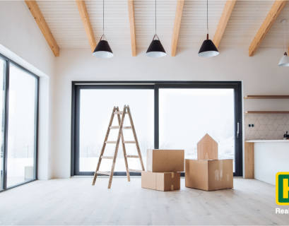 a ladder and moving boxes sitting in an empty room