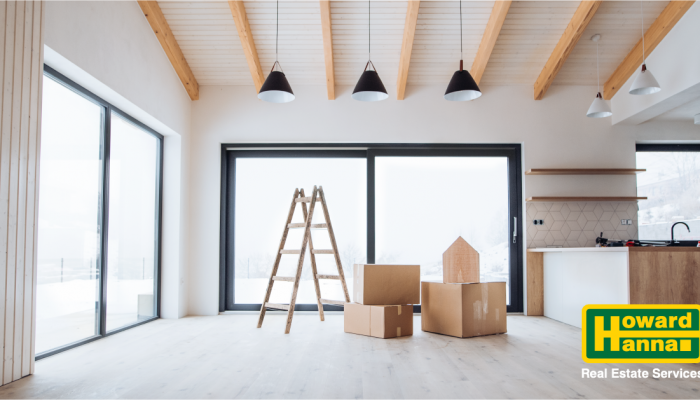 a ladder and moving boxes sitting in an empty room
